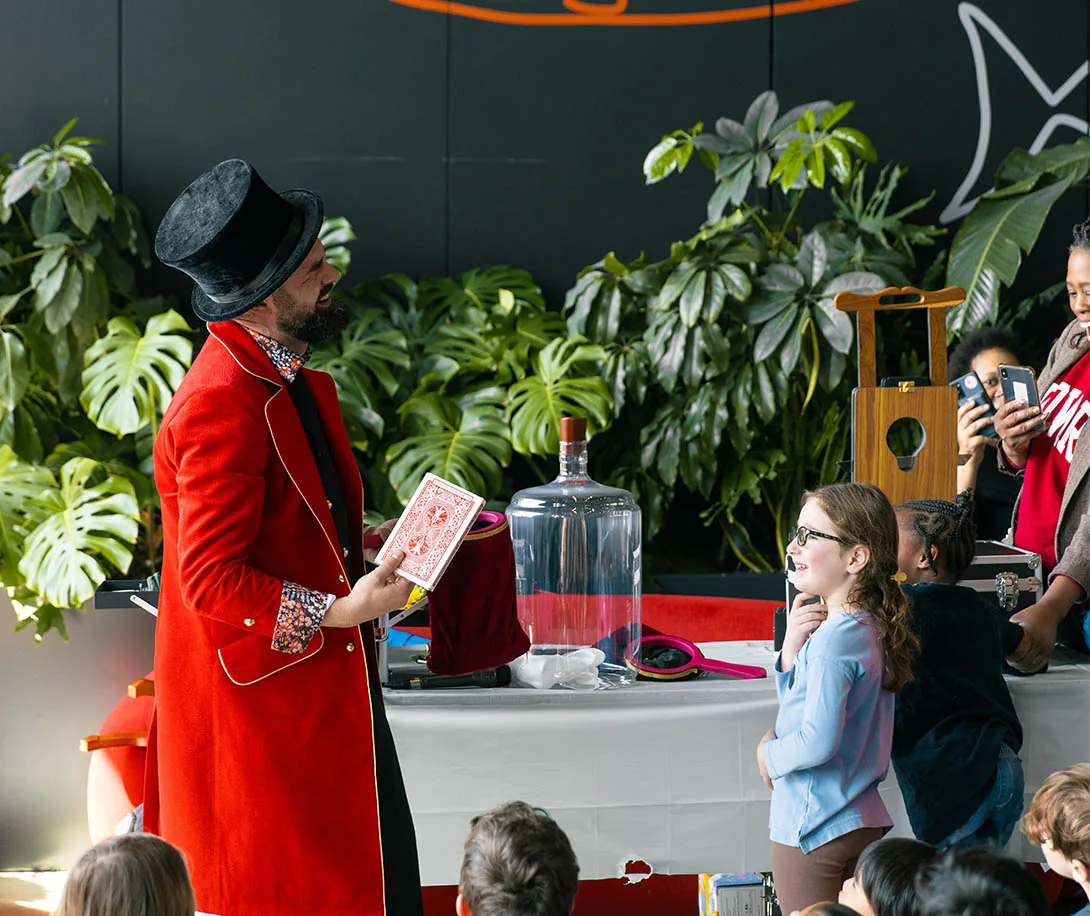 Nico performing a card trick with a young volunteer