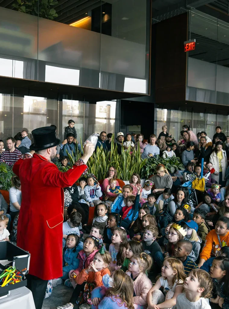 Children and parents watching Nico perform a family magic show